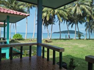 uma vista do alpendre de um resort com palmeiras em Happy Days Resort em Ko Mak