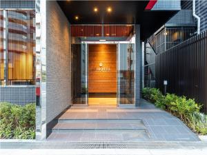 東京的住宿－Ai Hotel Keikyu Kamata，门上标有标志的建筑物入口