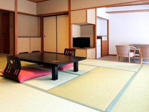 Hotel Yunojin في ميناكامي: غرفة معيشة مع طاولة تنس وكراسي