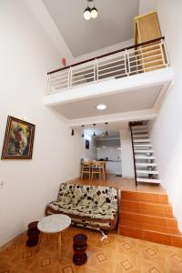 Cette chambre dispose d'une mezzanine avec un escalier et un canapé. dans l'établissement Timothy Homestay Hue, à Hue