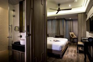 a hotel room with a bed and a desk and a bathroom at De Chai the Deco Chiang Mai - SHA Plus in Chiang Mai