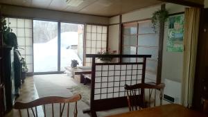 Habitación con 2 sillas, mesa y ventana en Lodge Amenouo, en Myoko