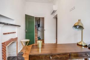 a kitchen with a wooden table and a green door at Saldanha Pool & Garden in Lisbon