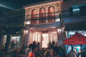 a group of people standing outside of a building at A Day inn Ranong Hostel in Ranong