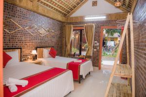 a bedroom with two beds and a brick wall at Tam Coc Three Princess Homestay in Ninh Binh