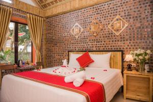 a bedroom with a large white bed with red pillows at Tam Coc Three Princess Homestay in Ninh Binh +49 photos