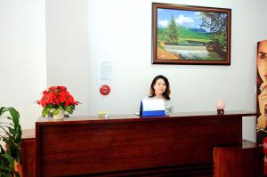 a woman sitting at a desk with a laptop at Anh Thư Hotel in Vung Tau
