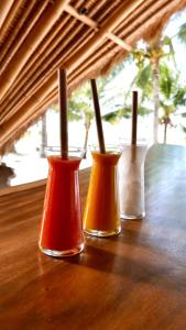Eco dive resort Alycastre في موميري: ثلاثة أواني ملونة مختلفة على طاولة خشبية