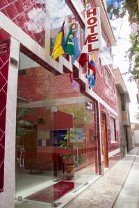 une fenêtre en verre d'un bâtiment avec drapeaux dans l'établissement Hotel Mi Casa, à Ayacucho