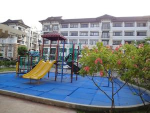 un parque infantil frente a un gran edificio en The Oasis Davao Condotel, en Davao City