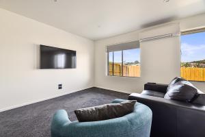 a living room with a couch and a tv at Southern Apartments Launceston in Launceston