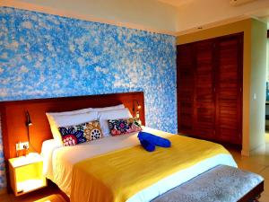 a bedroom with a large bed with blue wallpaper at VILLA KIKI Seychelles in Anse a La Mouche