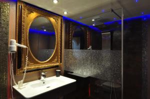 a bathroom with a sink and two mirrors at Pension & Spa de Watertoren in Zandvoort