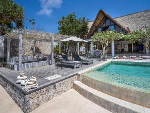 un patio trasero con piscina y una casa en Villa Voyage, en Nusa Lembongan