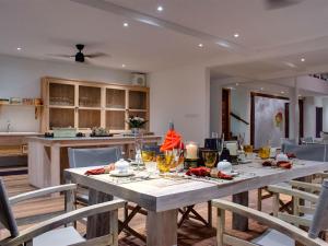 Un comedor con una mesa y una cocina. en Villa Voyage, en Nusa Lembongan