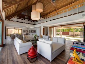 a living room with white couches and a table at Villa Voyage in Nusa Lembongan
