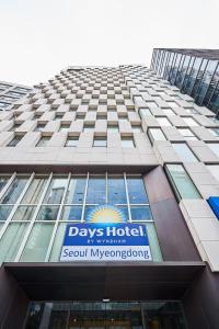 een hoog gebouw met een bord aan de zijkant bij Days Hotel by Wyndham Seoul Myeongdong in Seoul