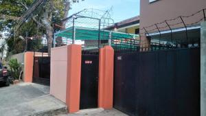 a building with a black gate and a fence at Peach Haven in Cebu City