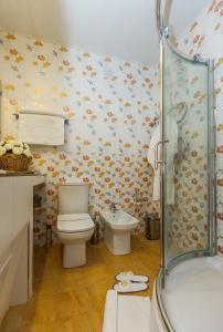 a bathroom with a toilet, sink, and bathtub at Grand Hotel Uyut in Krasnodar