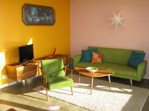 ラ・ロンド・レ・モールにあるBel Appart Style Vintage Vue Merのリビングルーム(緑のソファ、テーブル付)