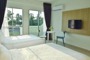 A bed or beds in a room at AVI Pangkor Beach Resort