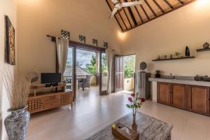a kitchen and living room with a television and a table at Villa Kubu Agung in Ubud