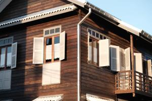 a house with white shutters and a balcony at บ้านเสงี่ยม-มณี Baan Sa ngiam-Manee in Sakon Nakhon