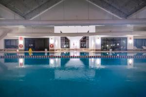 a large swimming pool with blue water in a building at Abant Palace Hotel in Abant