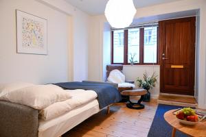 a bedroom with a bed and a chair and a table at Sanders Park - Charming 1-Bdr Apt Close to Metro in Copenhagen