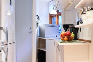 a kitchen with a bowl of fruit on a counter at Sanders Park - Charming 1-Bdr Apt Close to Metro in Copenhagen +14 photos