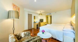 een hotelkamer met een bed, een bank en een tafel bij Jomtien Palm Beach Hotel and Resort - SHA Extra Plus in Jomtien Beach