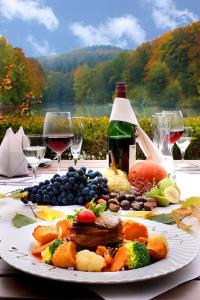 un plato de comida en una mesa con copas de vino en seehaus forelle haeckenhaus en Ramsen
