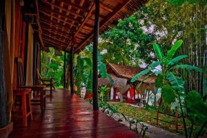 a porch of a house with a table and chairs at Sa Sa Lao in Luang Prabang