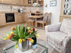 un salon avec une table et un vase de fleurs dans l'établissement Villa Caprivi 10, à Heringsdorf