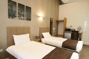 a hotel room with two beds and a television at Citilodge Wakefield Hotel by Roomsbooked in Wakefield