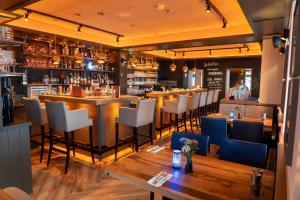 Nymphe Strandhotel & Apartments في بينز: مطعم مع بار مع طاولة وكراسي
