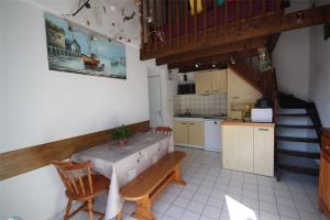 uma cozinha e sala de jantar com uma mesa e uma escada em 300m de la plage, adorable maison sud 2 chambres 5 couchages terrasse ombragée parking LRHP14 em Portiragnes