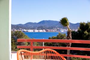 a red bench with a view of the water at Cubanito Ibiza in San Antonio
