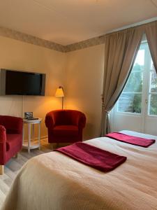 una camera con un grande letto e una sedia rossa di Nya Pallas Hotel a Falkenberg