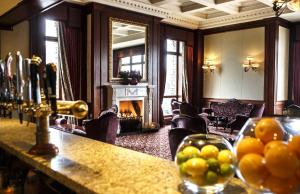 Mount Errigal Hotel, Conference & Leisure Centre في ليتيركيني: غرفة بها موقد وطاولة بها فاكهة