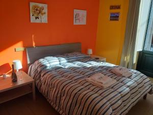 a bed in a bedroom with an orange wall at Bed Relax Etnaview Self check-in in Zafferana Etnea