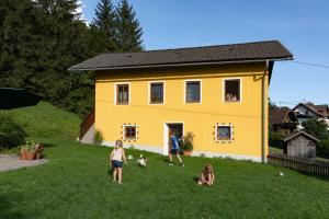 grupa dzieci przed żółtym domem w obiekcie Brunner - Ferienwohnung im Hühnerhotel w mieście Unterkolbnitz