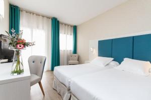 a hotel room with a white bed and white walls at Hotel Castilla Alicante in Alicante
