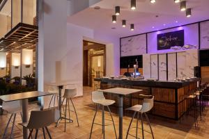 a bar in a restaurant with tables and chairs at Secrets Lanzarote Resort & Spa - Adults Only (+18) in Puerto Calero