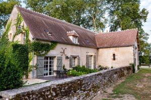 an old brick house with a stone wall at La ferme de Planchevienne in Magny-Cours