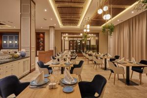 a restaurant with tables and chairs and a bar at Secrets Lanzarote Resort & Spa - Adults Only (+18) in Puerto Calero