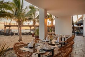 a restaurant on the beach with tables and chairs at Secrets Lanzarote Resort & Spa - Adults Only (+18) in Puerto Calero