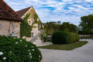 a stone house with stairs and bushes in front of it at La ferme de Planchevienne in Magny-Cours