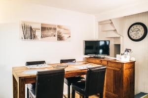 a desk with chairs and a tv and a desk with a computer at Violette avec parking privé sécurisé in Saint-Valéry-sur-Somme