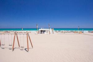 a sandy beach with umbrellas and the ocean at Hotel Castilla Alicante in Alicante